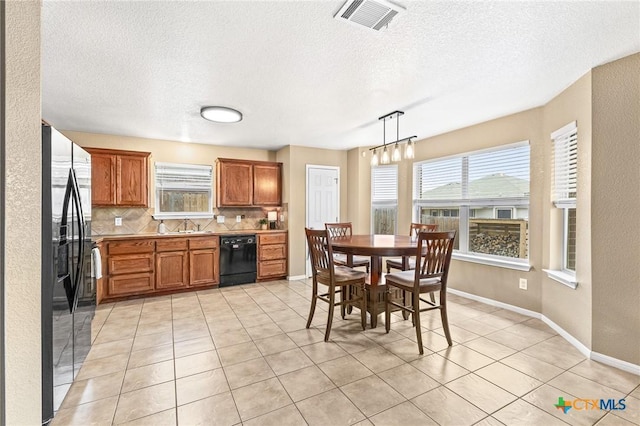 kitchen featuring backsplash, plenty of natural light, hanging light fixtures, and black appliances