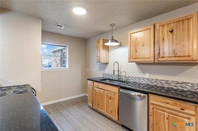 kitchen featuring visible vents, hanging light fixtures, stainless steel dishwasher, a sink, and light wood-type flooring