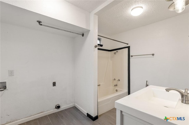 full bathroom featuring baseboards, a textured ceiling, shower / tub combination, and wood finished floors