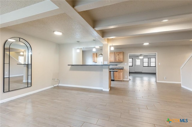 kitchen with dark countertops, open floor plan, decorative light fixtures, and light wood finished floors