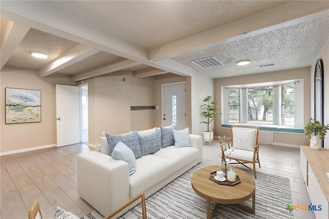 living room with a textured ceiling, visible vents, and light wood-style floors