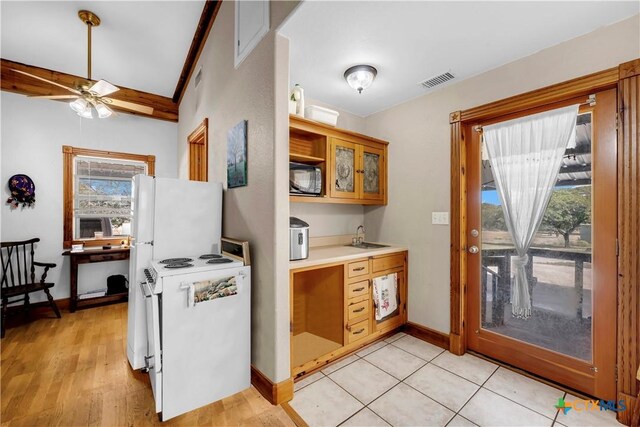 kitchen featuring a healthy amount of sunlight, sink, white appliances, and light tile patterned floors