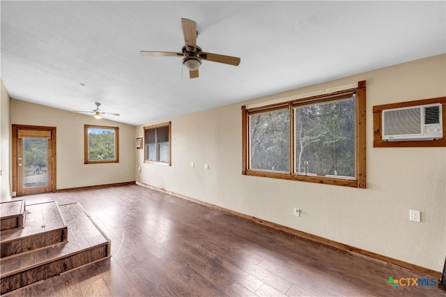 unfurnished living room with wood-type flooring, vaulted ceiling, a wall unit AC, and a wealth of natural light