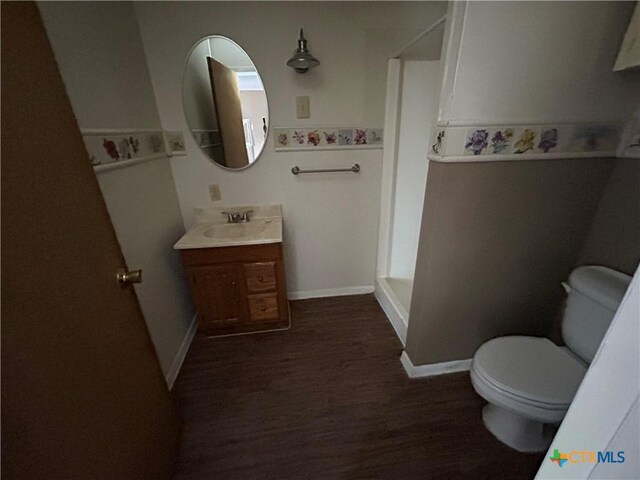 1511 E Constitution St, Victoria, TX 77901 - bathroom with a shower stall, toilet, wood finished floors, vanity, and baseboards