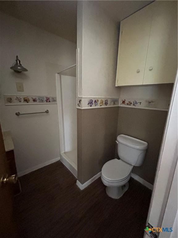 1511 E Constitution St, Victoria, TX 77901 - full bathroom with a stall shower, wood finished floors, toilet, and baseboards