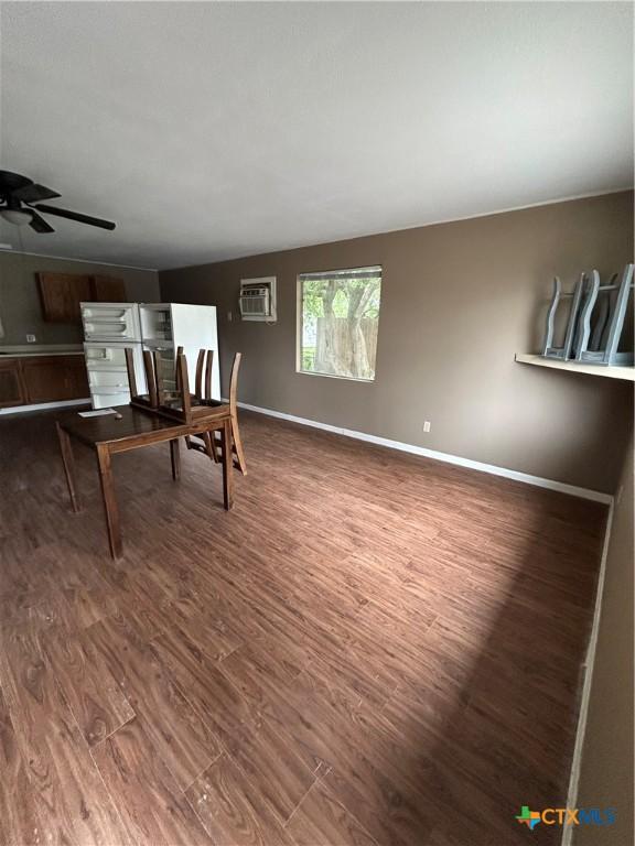 1511 E Constitution St, Victoria, TX 77901 - dining room with an AC wall unit, wood finished floors, a ceiling fan, and baseboards