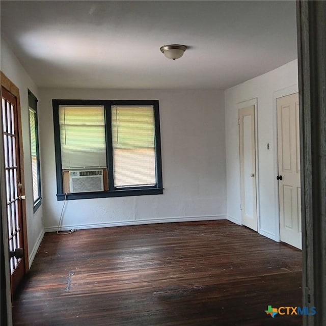 unfurnished room featuring cooling unit and dark hardwood / wood-style floors