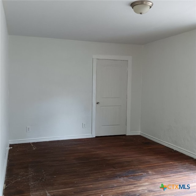 spare room with dark hardwood / wood-style flooring