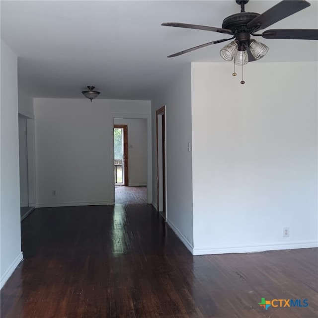 spare room with dark wood-type flooring and ceiling fan