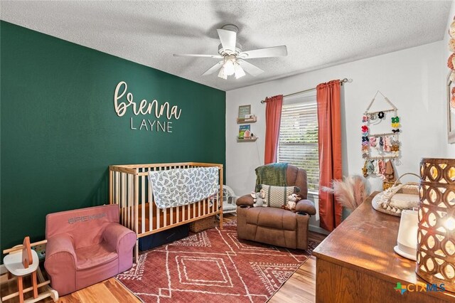 404 Innwood Dr, Georgetown, TX 78628 - bedroom featuring wood finished floors, a textured ceiling, and ceiling fan