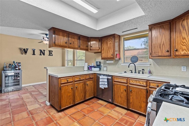 404 Innwood Dr, Georgetown, TX 78628 - kitchen with stainless steel appliances, a sink, beverage cooler, a peninsula, and brown cabinetry