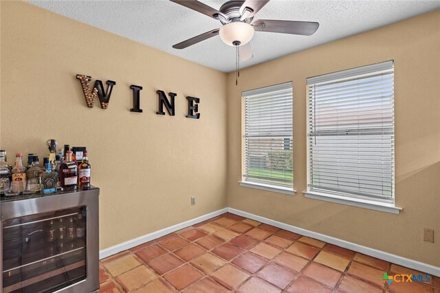 404 Innwood Dr, Georgetown, TX 78628 - spare room featuring wine cooler, ceiling fan, baseboards, a dry bar, and a textured ceiling