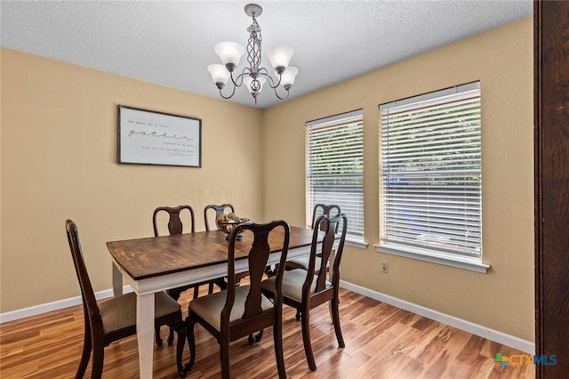 404 Innwood Dr, Georgetown, TX 78628 - dining area featuring a chandelier, baseboards, light wood-style flooring, and a textured ceiling