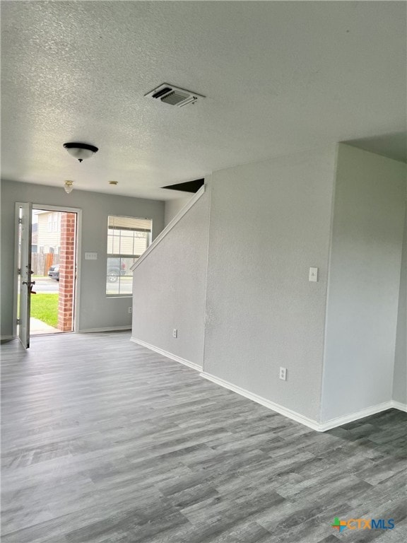 8619 Key N Way, Converse, TX 78109 - unfurnished room featuring wood finished floors, baseboards, stairway, and a textured ceiling