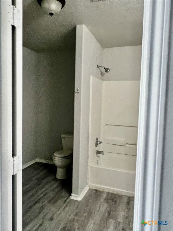 8619 Key N Way, Converse, TX 78109 - bathroom featuring toilet, wood finished floors, baseboards, bathing tub / shower combination, and a textured ceiling