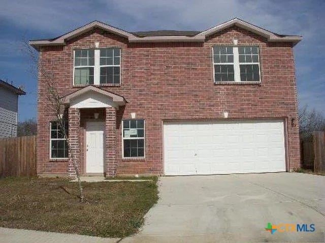 8619 Key N Way, Converse, TX 78109 - traditional-style house featuring an attached garage, driveway, fence, and brick siding