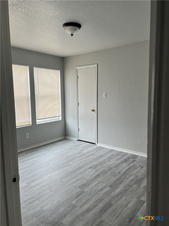 8619 Key N Way, Converse, TX 78109 - unfurnished room featuring a textured ceiling, wood finished floors, baseboards, and a textured wall