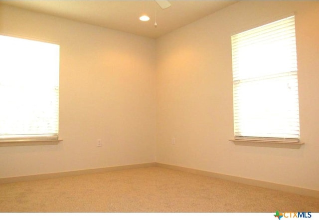 carpeted spare room featuring ceiling fan