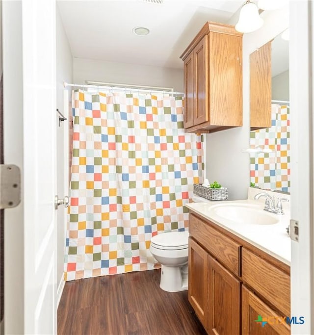 319 Silverado Trl, Victoria, TX 77901 - full bathroom with toilet, a shower with shower curtain, vanity, and wood finished floors