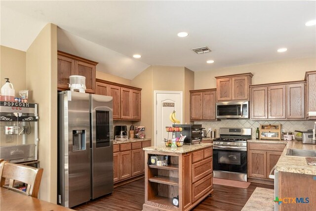 319 Silverado Trl, Victoria, TX 77901 - kitchen featuring dark wood-type flooring, appliances with stainless steel finishes, decorative backsplash, and open shelves