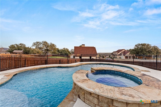 view of swimming pool with a pool with connected hot tub and fence