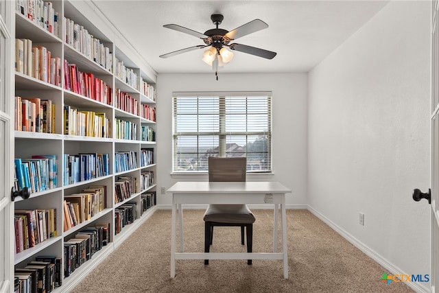 carpeted office with a ceiling fan and baseboards