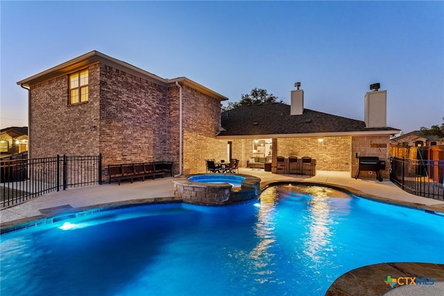 view of pool featuring a patio area, area for grilling, fence, and a pool with connected hot tub