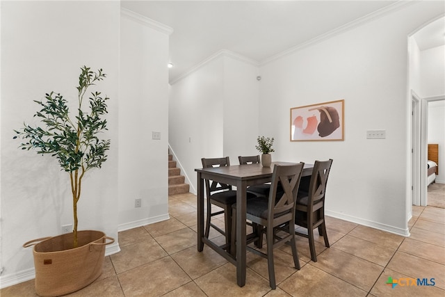 dining room featuring light tile patterned floors, ornamental molding, stairway, and baseboards