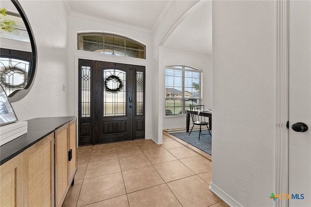 entrance foyer featuring light tile patterned floors, baseboards, and crown molding