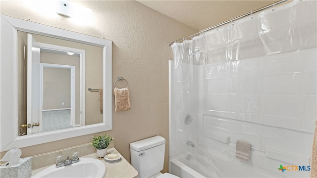 full bathroom featuring toilet, shower / tub combo, sink, and a textured ceiling