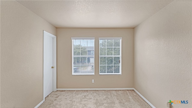 carpeted spare room with a textured ceiling