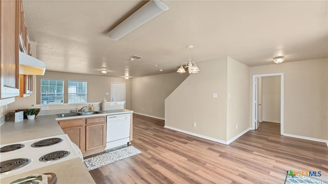 kitchen featuring decorative light fixtures, a notable chandelier, sink, white appliances, and light hardwood / wood-style flooring