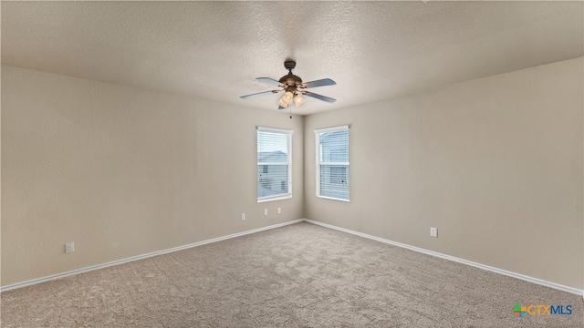 carpeted empty room with ceiling fan and a textured ceiling