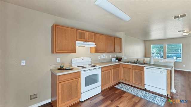 kitchen featuring sink, kitchen peninsula, dark hardwood / wood-style floors, a textured ceiling, and white appliances