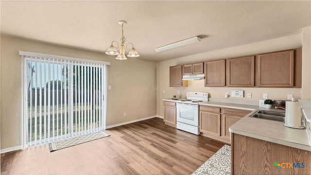 kitchen with white electric range oven, a notable chandelier, hanging light fixtures, sink, and light hardwood / wood-style flooring