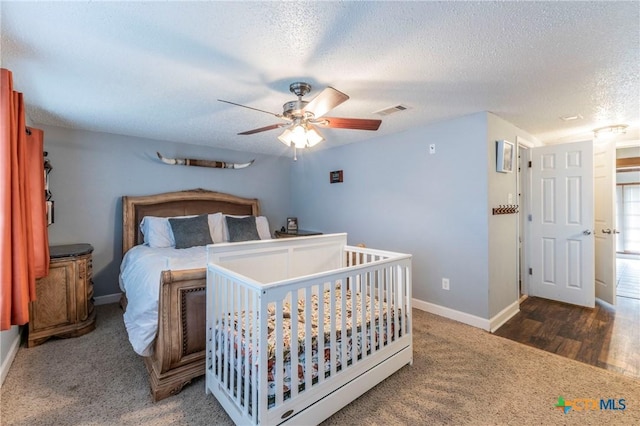 bedroom with a ceiling fan, baseboards, visible vents, a textured ceiling, and carpet flooring