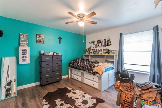 bedroom with ceiling fan, baseboards, and wood finished floors
