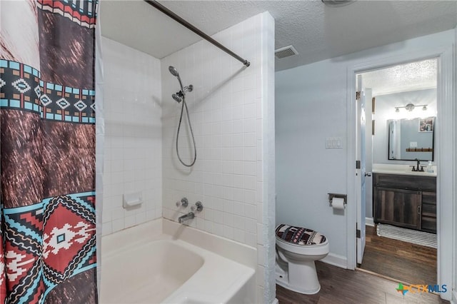 full bathroom with toilet, wood finished floors, visible vents, and a textured ceiling