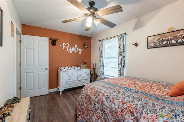 bedroom featuring dark wood finished floors, baseboards, a textured ceiling, and a ceiling fan