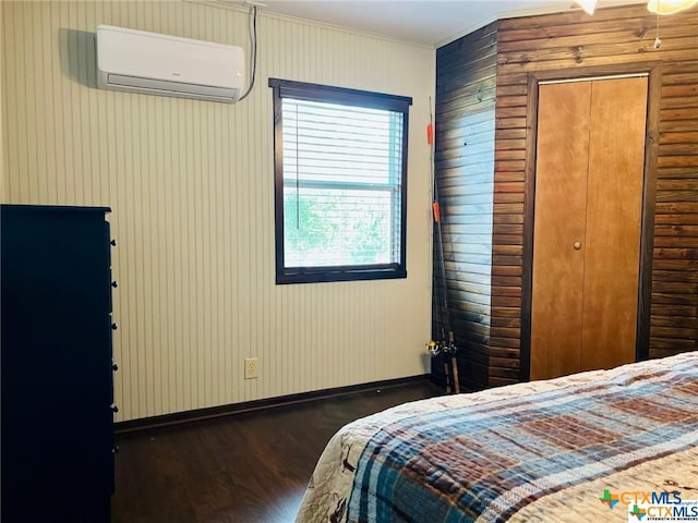 bedroom featuring a closet, ornamental molding, a wall unit AC, and dark hardwood / wood-style floors