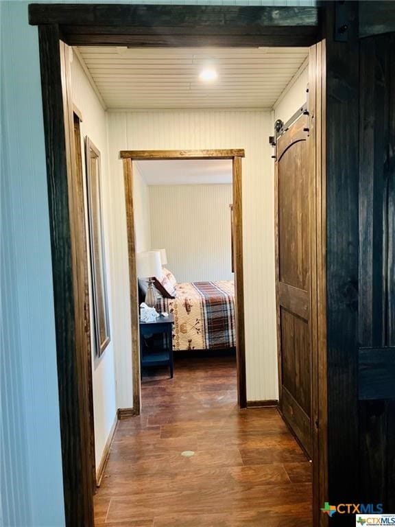 hallway featuring dark hardwood / wood-style floors and a barn door