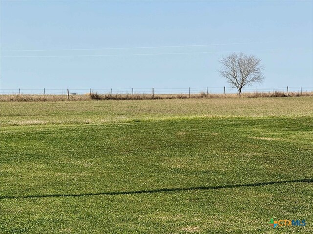 view of yard with a rural view and fence