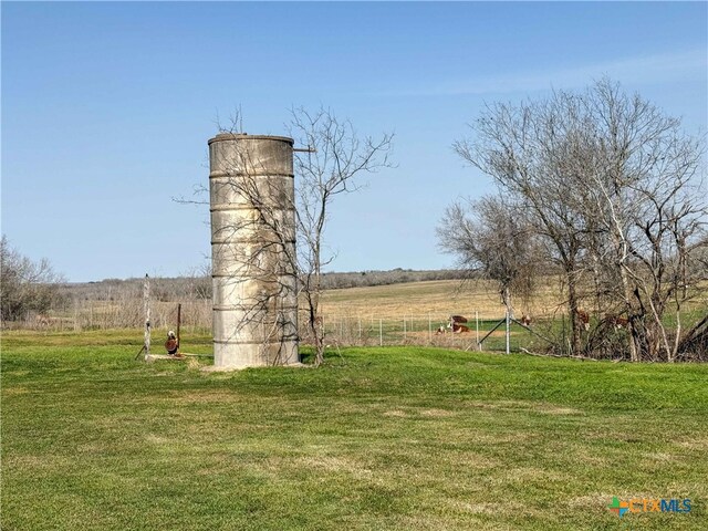view of home's community with a rural view and a lawn