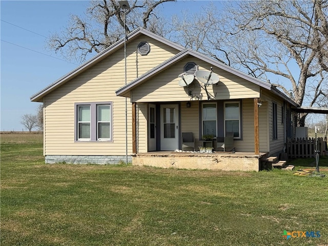 view of front of property with a porch, fence, and a front lawn