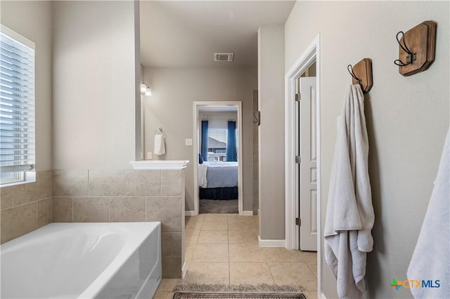 bathroom featuring ensuite bathroom, tile patterned flooring, visible vents, and a bath