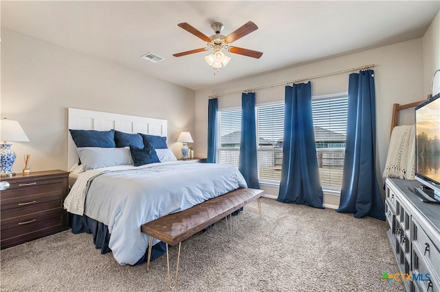 bedroom with visible vents, a ceiling fan, and light colored carpet