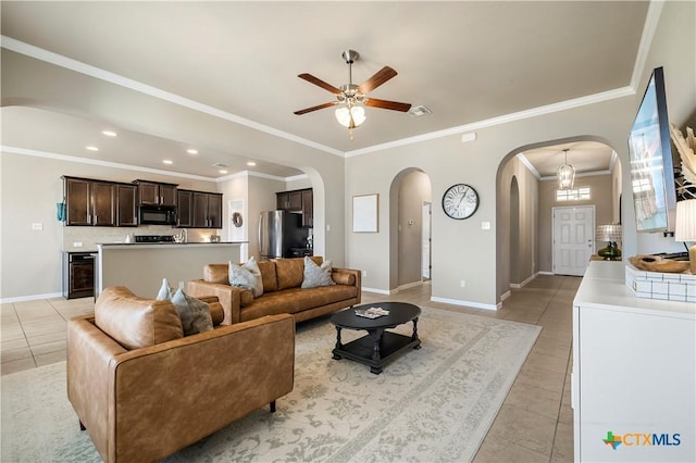 living area with a ceiling fan, arched walkways, baseboards, and light tile patterned floors