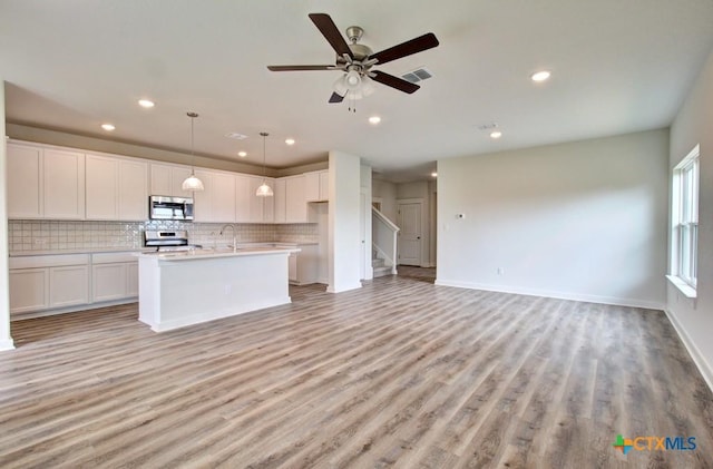 3644 Meteor Rd, New Braunfels, TX 78130 - kitchen with recessed lighting, stainless steel appliances, backsplash, white cabinetry, and open floor plan
