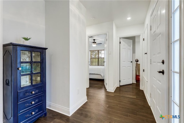 hallway featuring recessed lighting, dark wood finished floors, and baseboards