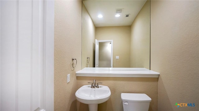 322 Wauford Way, New Braunfels, TX 78132 - bathroom with a textured wall, toilet, a sink, and recessed lighting